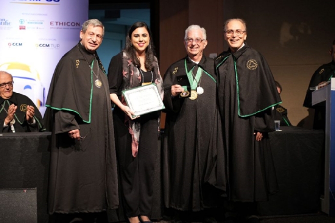 Imagem do Prof. Dr. Osvaldo Malafaia no palco recebendo sua medalha.
